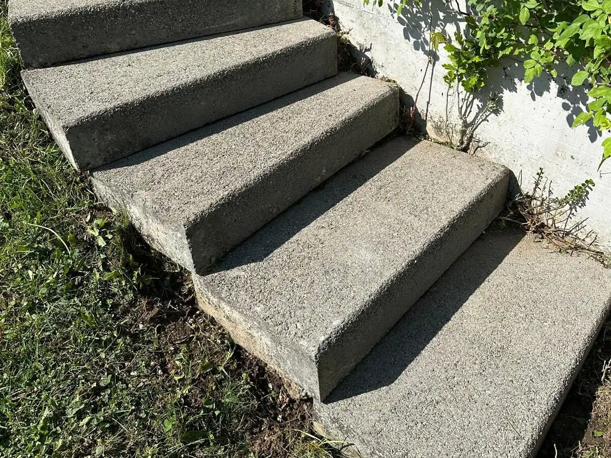 Betontreppe im Garten, links dicht mit Moos bewachsen, rechts nach der Reinigung., nach der Reinigung